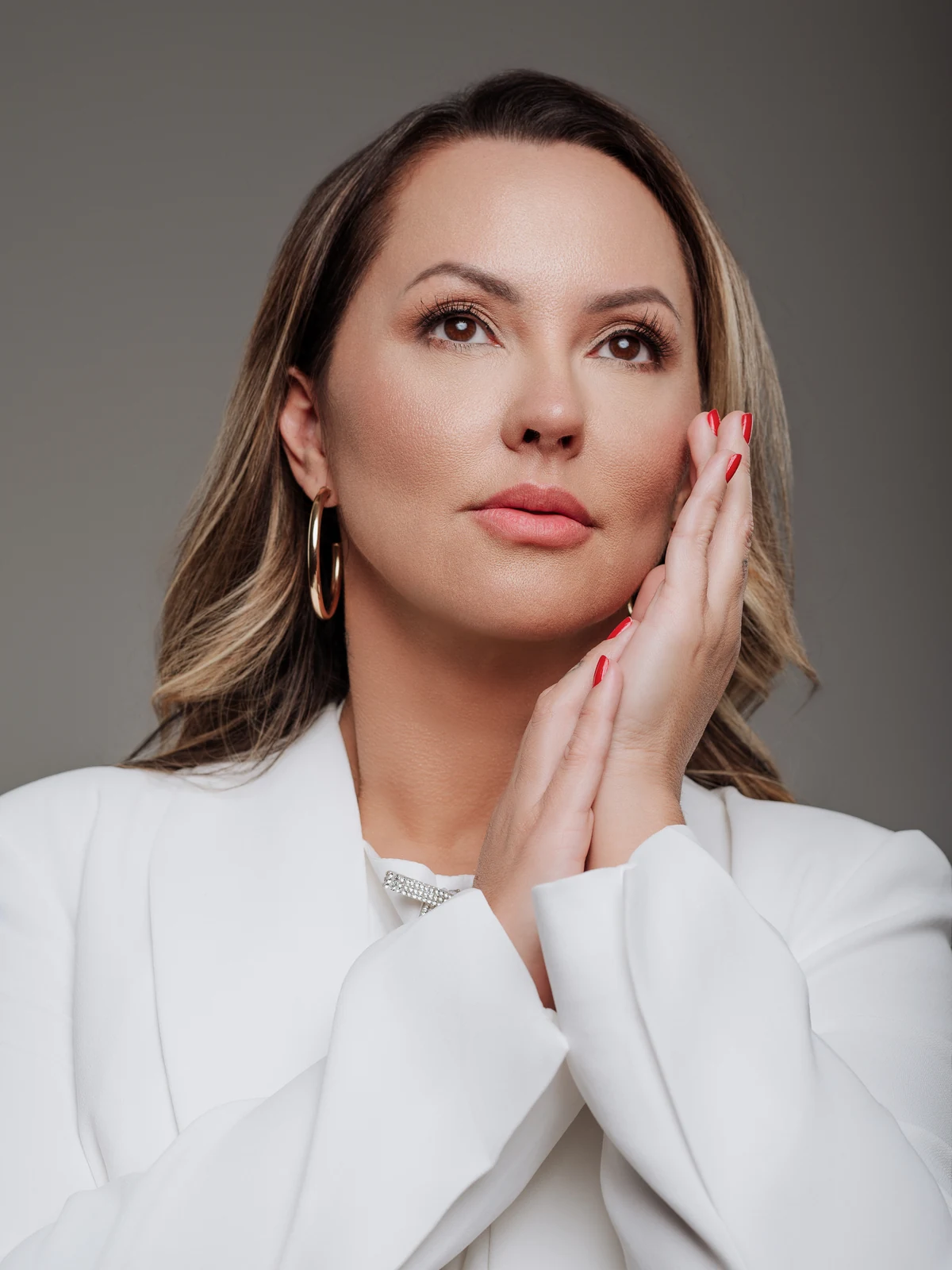 Dra. Joan Mason de blazer branco, com as mãos apoiadas no rosto